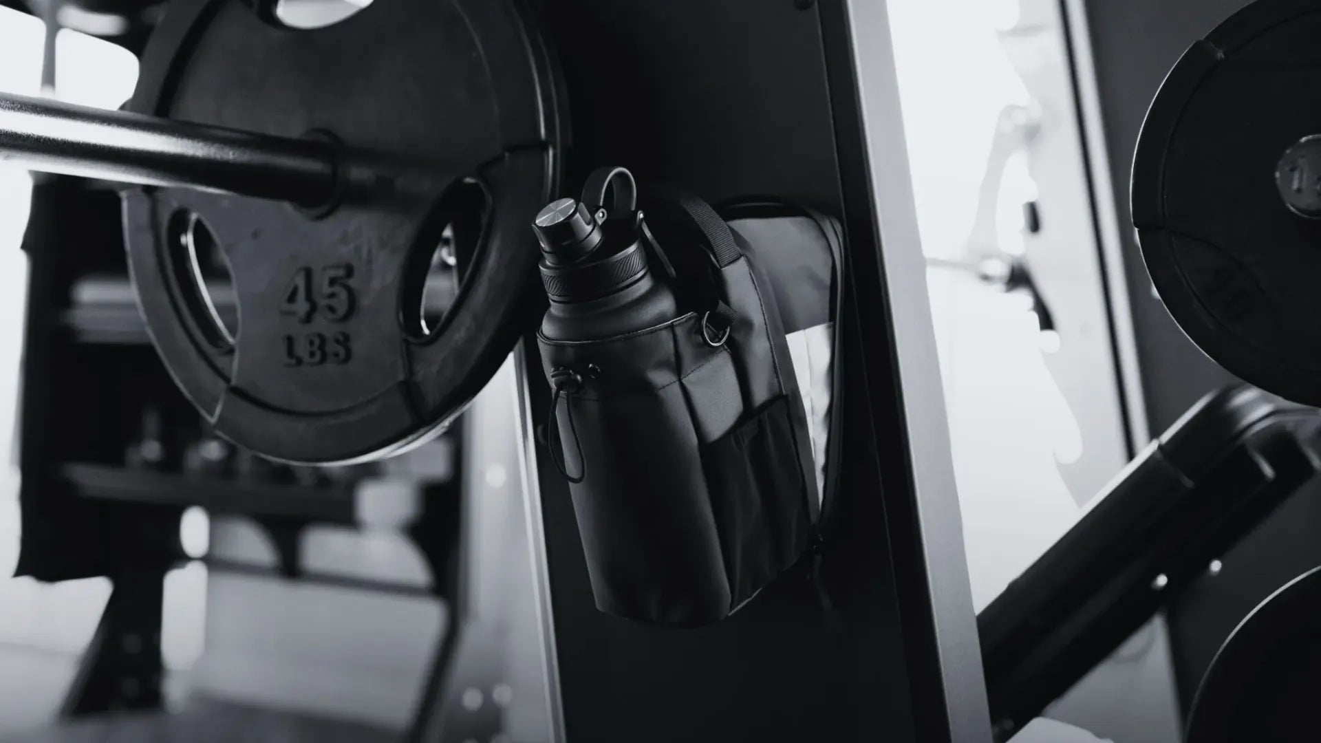 Bolsa magnética de gimnasio con botella de agua sujeta a rack de pesas, diseño funcional para entrenamiento organizado