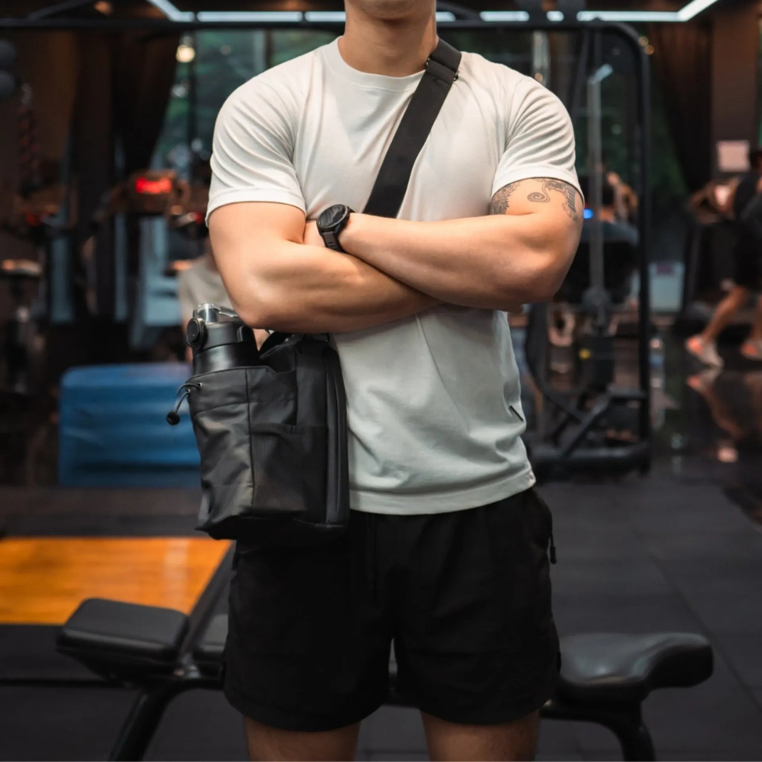 Bolsa magnética para gimnasio usada por atleta, con portabotella y correa cruzada durante entrenamiento en interior