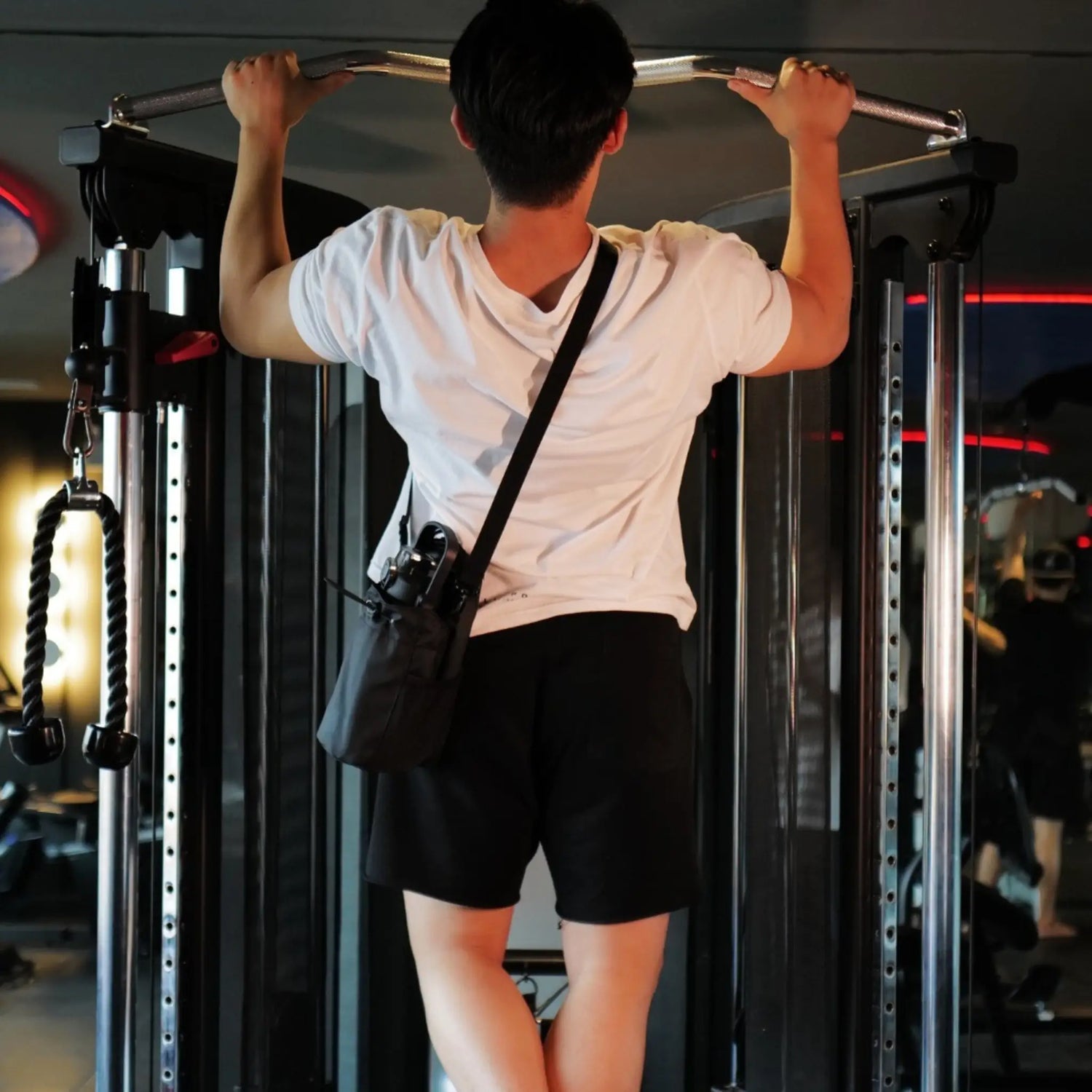 Bolsa magnética para gimnasio usada durante dominadas en máquina de entrenamiento